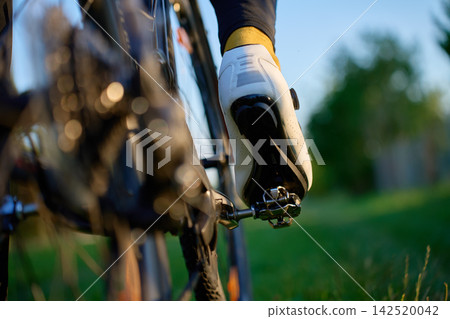 Close-up of a cyclist shoe clipped into the bike pedal. 142520042