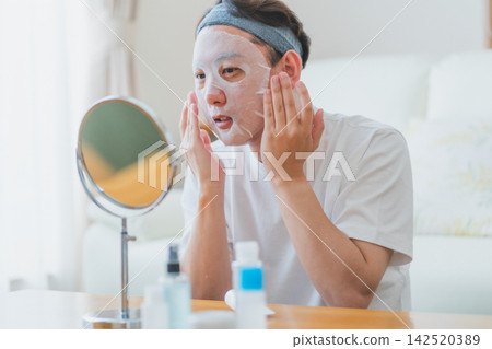 40歲男子的美容秘訣:用雙手將面膜牢牢地按壓在臉上。 40歲男子的美容秘訣:用雙手將面膜牢牢地按壓在臉上。 142520389