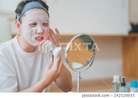 在這段男士美容影片中,一位四十多歲的男子麵帶微笑地使用臉部美容儀敷面膜進行護膚。 在這段男士美容影片中,一位四十多歲的男子麵帶微笑地使用臉部美容儀敷面膜進行護膚。 142520935