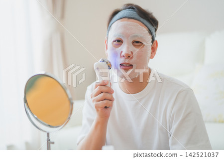 四十多歲男士的美容程序包括在敷面膜後使用臉部美容儀進行全套護膚護理。 四十多歲男士的美容程序包括在敷面膜後使用臉部美容儀進行全套護膚護理。 142521037