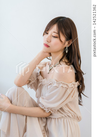 A Japanese woman sits elegantly, adorned with jewelry. An elegant fashion portrait. A Japanese woman sits elegantly, adorned with jewelry. An elegant fashion portrait. 142521362