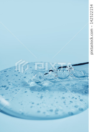 Pipette dipping into clear blue gel with bubbles, creating hydrating texture Pipette dipping into clear blue gel with bubbles, creating hydrating texture 142522154