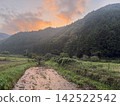 A beautiful sunrise paints the river flowing through the mountain village. 142522542