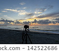 Taking pictures at sunset over the sea 142522686