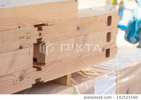 Processed lumber lined up at a wooden house construction site. Structural materials for the house to be used during the roof-raising ceremony. Processed lumber lined up at a wooden house construction site. Structural materials for the house to be used during the roof-raising ceremony. 142523160