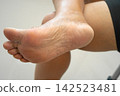 Asian woman care feet with cracked and dry heel skin cream at home. 142523481