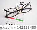 Glasses on eye testing exam chart to check eyesight accuracy of reading. 142523485