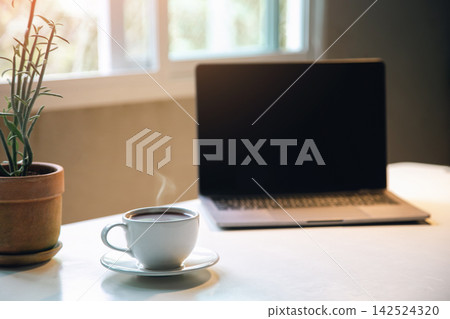 aroma coffee cup on the table with laptop home office in the morning, Energy drink before starting work concept. close up aroma coffee cup on the table with laptop home office in the morning, Energy drink before starting work concept. close up 142524320