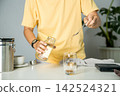 Man poured instant coffee powder making hot coffee into the cup with an equipment tool digital scale on the wooden bar in the kitchen. brew coffee home 142524321