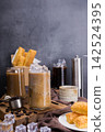 Asian iced coffee in transparent glass and roasted coffee beans and Crispy Pie on wood. black background studio photo, Copy space for your text 142524395