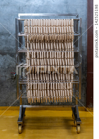 Fresh Raw Sausages Hanging on Racks in Food Processing Factory Fresh Raw Sausages Hanging on Racks in Food Processing Factory 142525198
