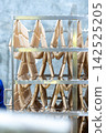 Fresh Raw Sausages Hanging on Racks in Food Processing Factory 142525205