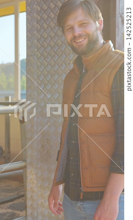 Vertical video. Young farmer caring for cows in a barn. Dairy farm professional concept. Vertical video. Young farmer caring for cows in a barn. Dairy farm professional concept. 142525213