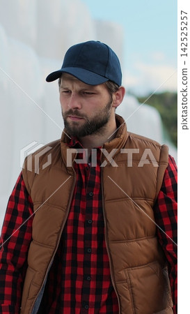 Vertical video. Close up of professional agronomist walking hay stack on season countryside. Agribusiness owner check bales pile at autumn farmland. Modern organic agribusiness. 142525257