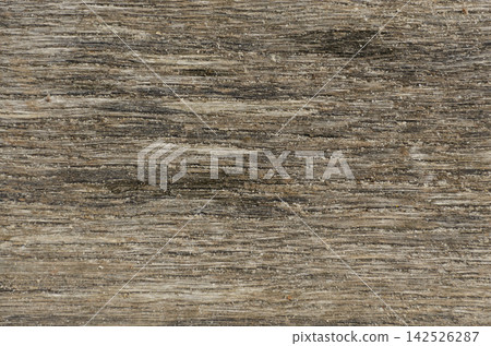 Weathered driftwood texture with fine sand grains. Aged natural wood background ideal for eco branding, beach themes, and rustic web design Weathered driftwood texture with fine sand grains. Aged natural wood background ideal for eco branding, beach themes, and rustic web design 142526287