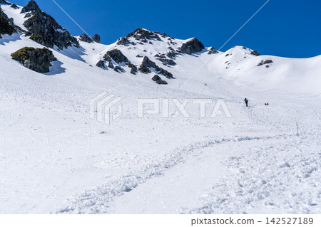 從北穗澤登山路線上看到的北穗高山山頂和島嶼景色:在初夏雪融季節攀登北阿爾卑斯山的北穗高山。 從北穗澤登山路線上看到的北穗高山山頂和島嶼景色:在初夏雪融季節攀登北阿爾卑斯山的北穗高山。 142527189