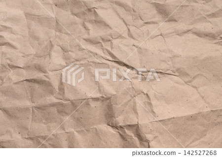 Wrinkled creased brown kraft paper sheet. Textured surface with organic folds. Rustic grunge backdrop. Eco-friendly packaging concepts Wrinkled creased brown kraft paper sheet. Textured surface with organic folds. Rustic grunge backdrop. Eco-friendly packaging concepts 142527268
