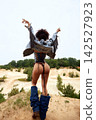 Fashionable woman with curly hair from behind in revealing denim outfit outdoors 142527923