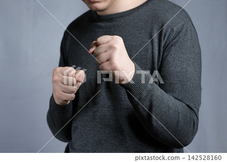 Man With Fists Raised in Boxing Stance Showing Anger, Aggression and Self-Defense Readiness 142528160