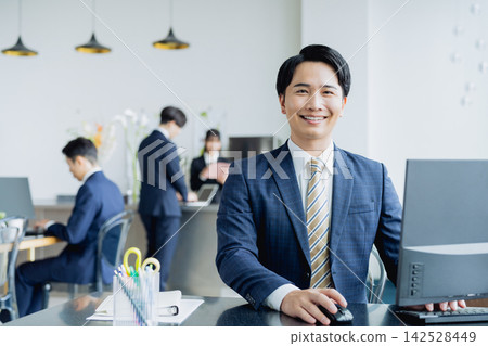 工作在辦公室的一個年輕商人 工作在辦公室的一個年輕商人 142528449