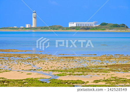 Naha Airport control tower as seen from the beach at Umikaji Terrace on Senaga Island in Tomigusuku City, Okinawa Prefecture. Naha Airport control tower as seen from the beach at Umikaji Terrace on Senaga Island in Tomigusuku City, Okinawa Prefecture. 142528549