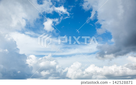 Serene blue sky with fluffy clouds and soft, white wisps during the day 142528871