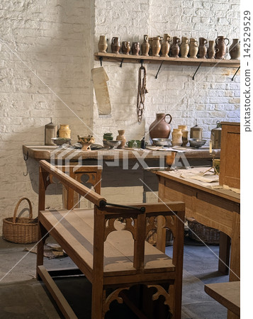 Historic Tudor Kitchen Interior with Antique Pottery, Wooden Bench, and Rustic Table Historic Tudor Kitchen Interior with Antique Pottery, Wooden Bench, and Rustic Table 142529529