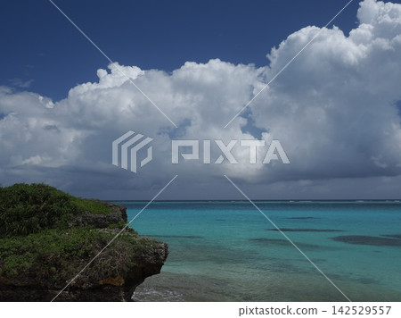 碧綠的淺灘和巨大的夏日雲朵。池間島船楠海灘的海岸風光。 碧綠的淺灘和巨大的夏日雲朵。池間島船楠海灘的海岸風光。 142529557