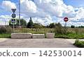 Pedestrian crossing blocked with concrete barriers near road signs in an urban area under cloudy sky. Road closure and restricted access concept. 142530014