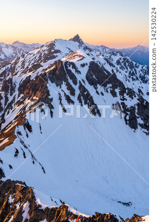 Mt. Yarigatake bathed in the sunset as seen from Kitahotaka Hut (magic hour) - Climbing Mt. Kitahotaka in the Northern Alps during early summer when snow remains. Mt. Yarigatake bathed in the sunset as seen from Kitahotaka Hut (magic hour) - Climbing Mt. Kitahotaka in the Northern Alps during early summer when snow remains. 142530224