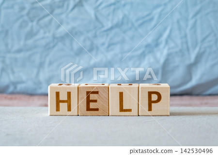 motivational word Help is laid out from letters on wooden cubes motivational word Help is laid out from letters on wooden cubes 142530496