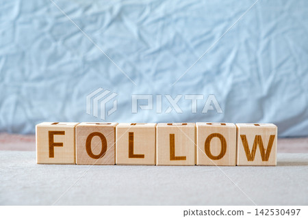 motivational word Follow is laid out from letters on wooden cubes motivational word Follow is laid out from letters on wooden cubes 142530497