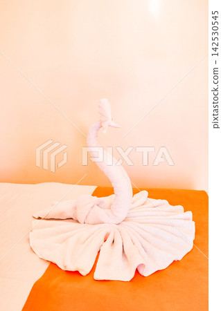 swan folded out of towels on hotel bed 142530545