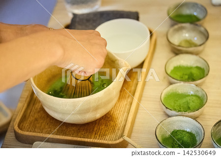 Preparing matcha tea using traditional bamboo whisk Preparing matcha tea using traditional bamboo whisk 142530649