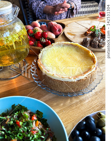 Homemade cheesecake served on wooden table in close friend circle. Celebrating holiday and birthday Homemade cheesecake served on wooden table in close friend circle. Celebrating holiday and birthday 142531304