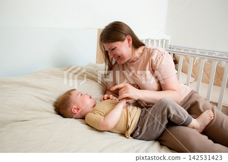 Close up of mother and son exchanging loving hugs and giggles. Perfect illustration of secure attachment and childhood happiness Close up of mother and son exchanging loving hugs and giggles. Perfect illustration of secure attachment and childhood happiness 142531423