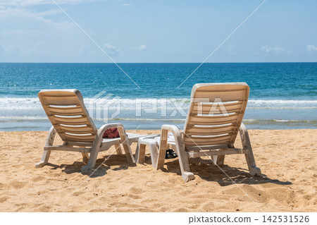 white plastic lounge chairs on Baan Krood sandy beach, Prachuap white plastic lounge chairs on Baan Krood sandy beach, Prachuap 142531526