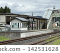 A local train station platform and pedestrian overpass under a cloudy sky – a typical scene on a local line. 142531628
