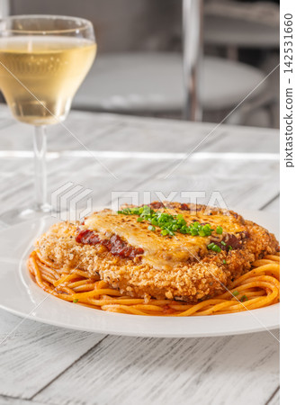 Chicken Parmesan with spaghetti white wine and Italian bistro table setting breakfast Chicken Parmesan with spaghetti white wine and Italian bistro table setting breakfast 142531660