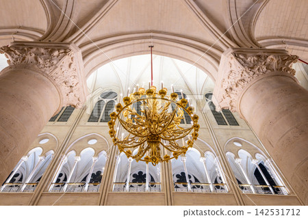 The interior of Notre Dame Cathedral in Paris, with its beautiful chandeliers and Gothic arches. 142531712