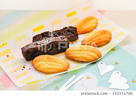 Homemade madeleines, brownies, and wrapping materials Homemade madeleines, brownies, and wrapping materials 142531780