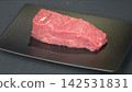 Prime cut fresh raw beef tenderloin steak portion served on modern black rectangular plate, gourmet culinary ingredient 142531831