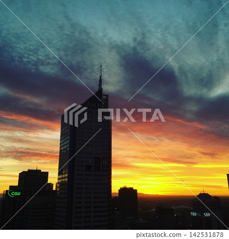 黃昏時分的城市景觀,透過雲層的縫隙清晰可見。 黃昏時分的城市景觀,透過雲層的縫隙清晰可見。 142531878