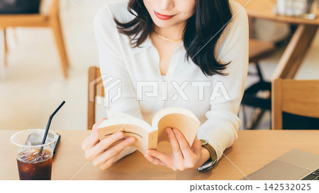 A woman reading at a cafe A woman reading at a cafe 142532025