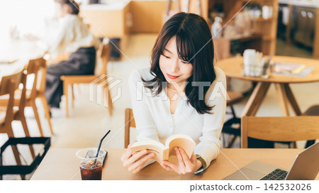 A woman reading at a cafe A woman reading at a cafe 142532026