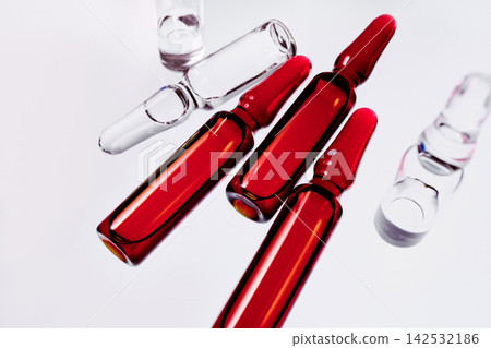 Red and transparent ampoules with medicine symbolizing medicine, research and treatment Red and transparent ampoules with medicine symbolizing medicine, research and treatment 142532186