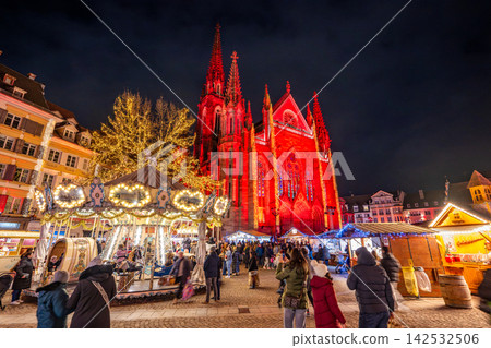 The Christmas market in Place Réunion and the Saint-Étienne Church lit up in red in Mulhouse, France. The Christmas market in Place Réunion and the Saint-Étienne Church lit up in red in Mulhouse, France. 142532506