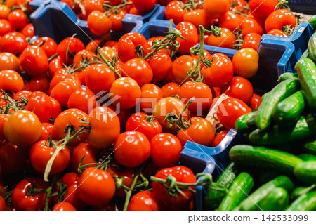 Bright Red Vine Tomatoes and Fresh Cucumbers in Produce Crates Bright Red Vine Tomatoes and Fresh Cucumbers in Produce Crates 142533099