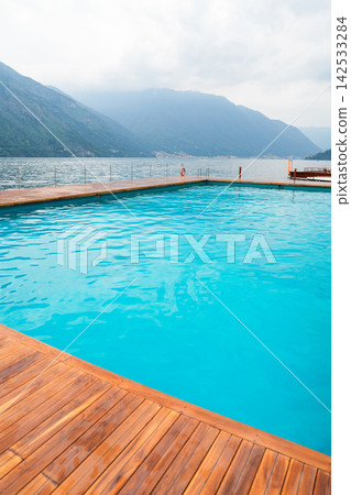 Pool near Hotel Tremezzo at Como Lake and mountain lake view at outdoor resort Pool near Hotel Tremezzo at Como Lake and mountain lake view at outdoor resort 142533284