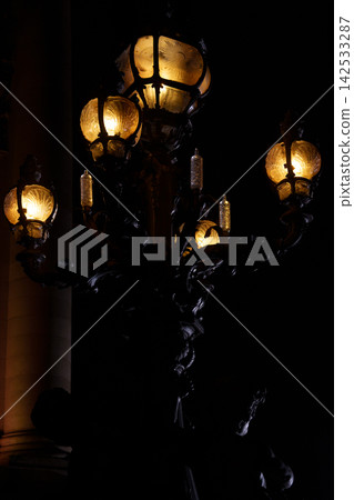 Vintage ornate street lamp glowing at night in city Vintage ornate street lamp glowing at night in city 142533287